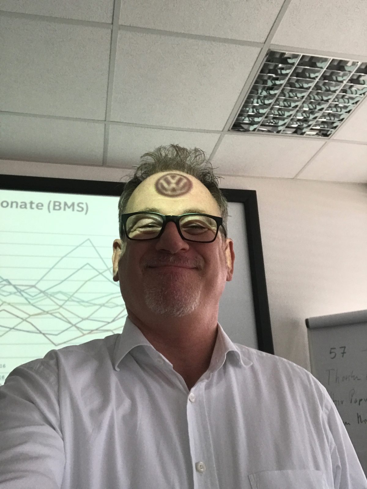 Martin Buchstaller smiling in glasses and a white shirt, with a Volkswagen logo humorously placed on his forehead